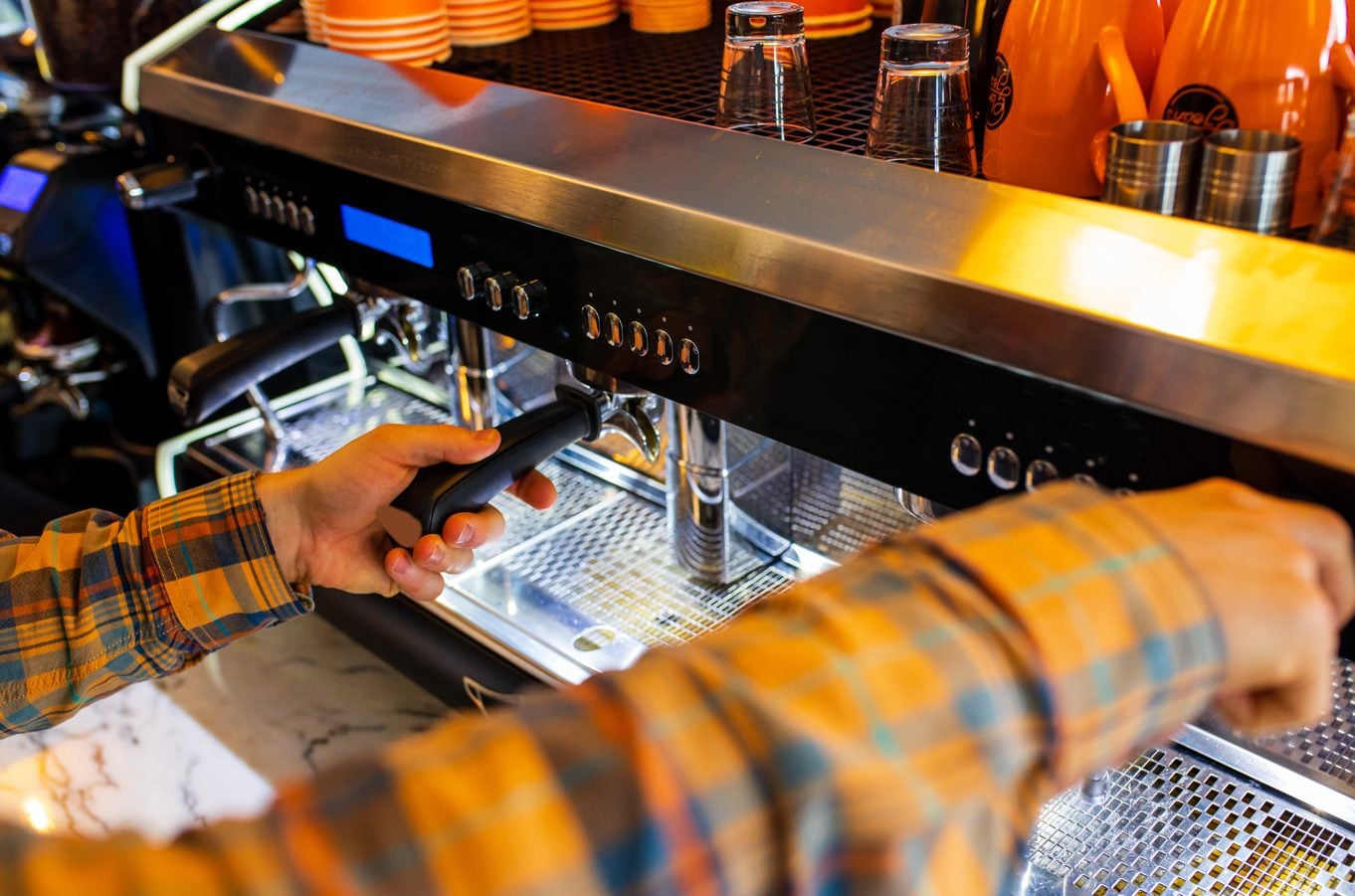 Barista operating a commercial espresso machine