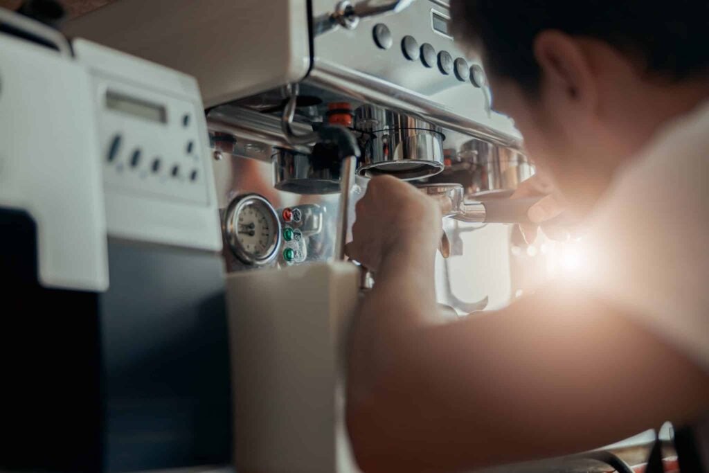 Technician reading error code on commercial coffee machine in UK cafÃ© 2025